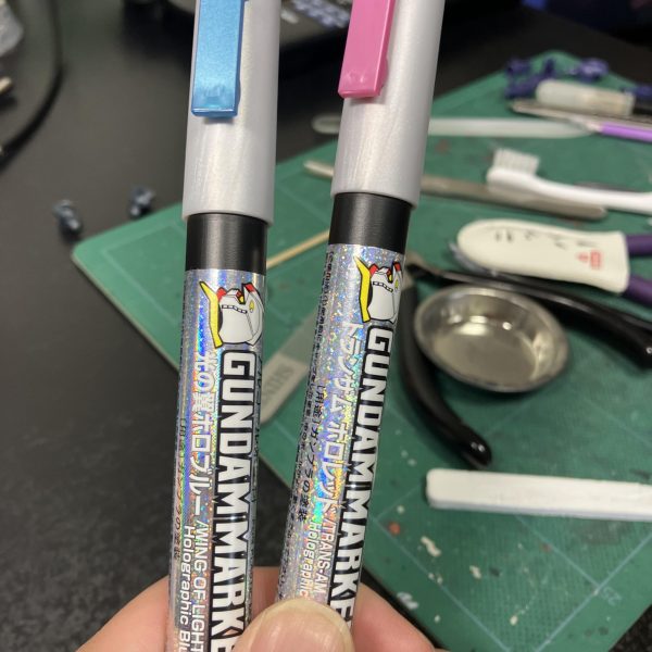 ガンダムマーカーEX トランザム ホロレッドと同じく 光の翼ホロブルーに挑戦😉相互フレの巨匠からのアドバイスもあり、プレバン特有の余剰パーツを使って試し塗り、SDGｓですね🥳かなり適当に塗りましたが、期待以上の輝きとキメ細かさに驚嘆🤩🤩しかし、段差やモールドがあると確かに難しい😵‍💫クリアーパーツの上からでもこの見た目が維持できるのか不安ですが、とりあえず今回もクリアパーツの研磨もしないとですね〜🥴（2枚目）