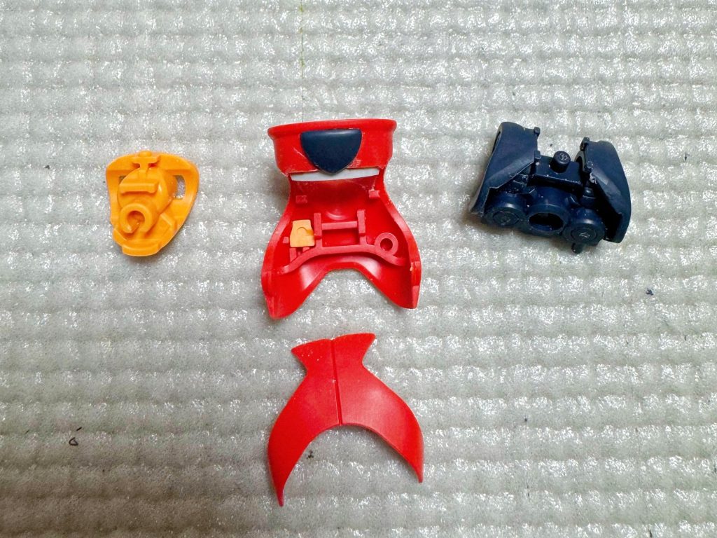 胸のプロテクターの後ハメ加工です。襟の部分で分割してます。詳しくは「ふわとろ大尉」さんのYouTubeで。追加したことといえば、切断したところとの間が見えて中がないのが見える感じだったので薄いプラ板を入れて目隠ししています。逆三角形の紺色パーツですが、反対側にピンが出るので接着してます。