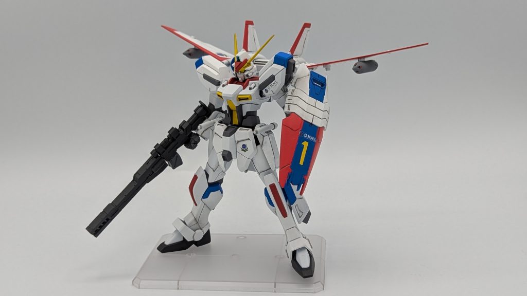 誰がどう見ても分かると思いますが、ドラグナー１に寄せました。キャバリアーもいるし、ドラグナーに似てる機体がいてもいいじゃろ…。　今回のこだわりポイントは顔と盾です。顔はAGE-１のものがピッタリとハマったので、への字スリットをパテで埋めて使用しています。盾はガンダムジェミナスのものを使用。そのままだとうまくジョイントに接続できなかったので瞬着で軸を太らせて調整しています。また特徴的な盾のナンバリングはいい感じのデカールがなかったので、塗装で再現しています。