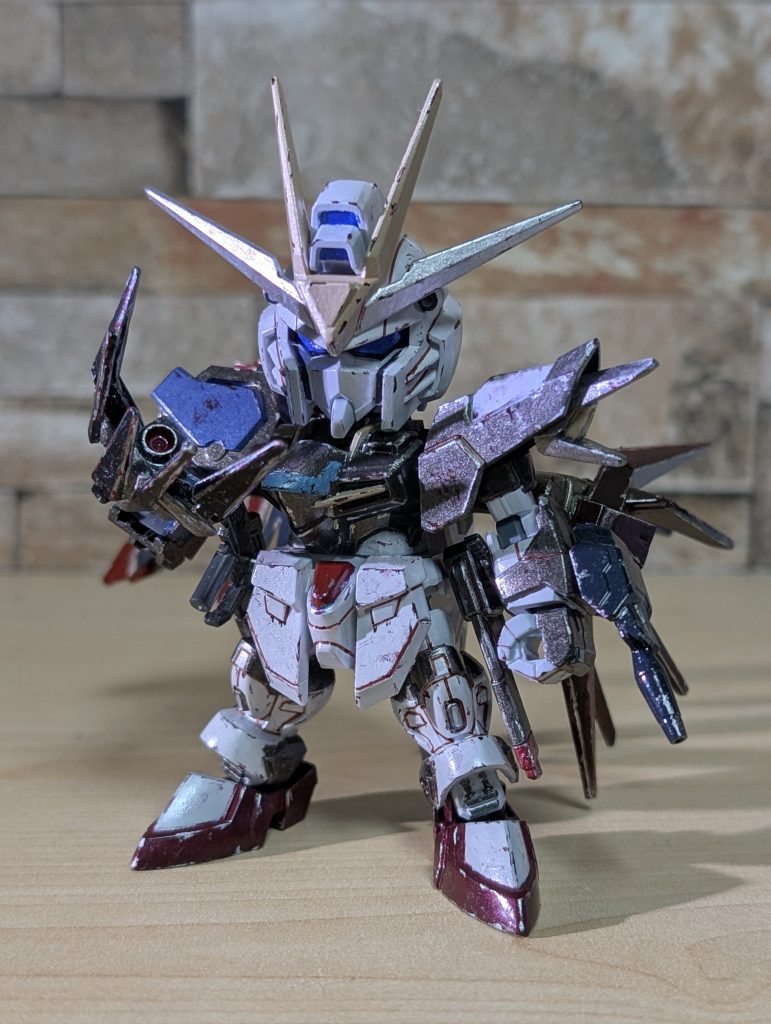 破壊された部位のうち、右腕はストライクの腕+オリジナルの爪、左翼はエールストライクのブースターにウイングを盛ったもの、おまけに右レールガンを短くしたエールストライクのライフルでそれぞれ置き換えました。同時に、カラーリングをダークヒーローっぽく変更しました。劇場版前半の重めの雰囲気をイメージした感じでもあります。