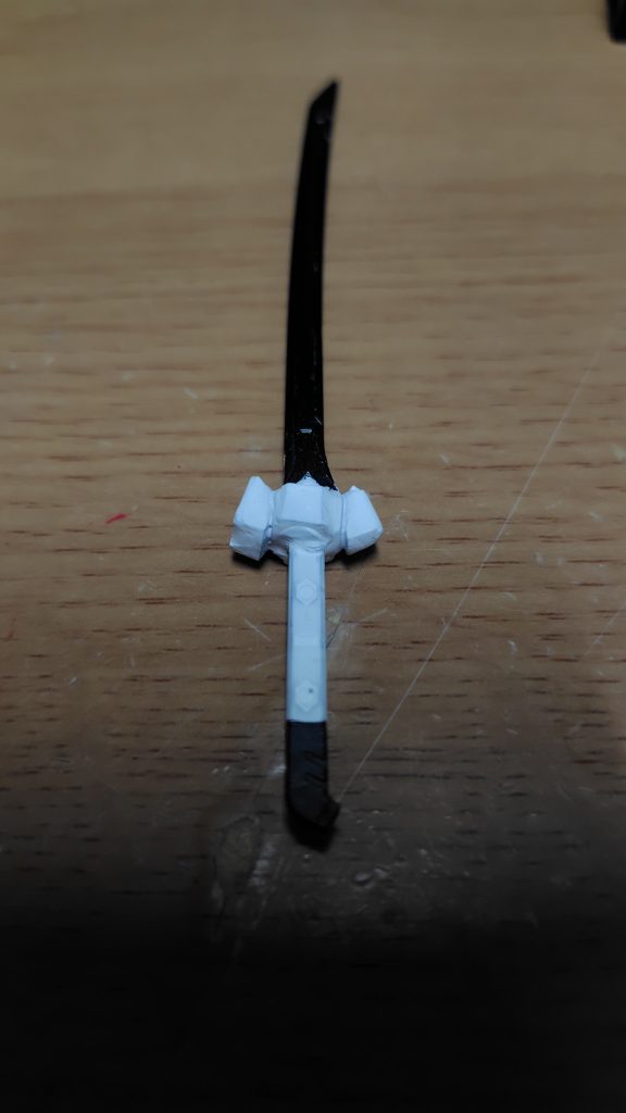 ジン、シグーの重斬刀の鍔を形どってレジン流し込んで成形。柄と鍔を水性ホビーカラーで、刀身を黒鉄色に塗装。
