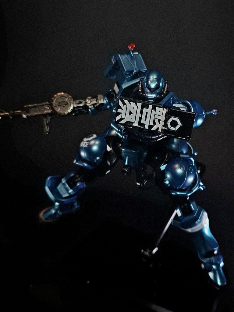 シールド実体タイプのシールド。右肩のL字型シールドと左前腕部の携行式シールドを装備されている。L字型シールドは短縮されている。左前腕部のシールドには所属を示す「警察」の二文字がピクトグラムめいて大書されている。イズマ・コロニーに駐在している関係か公用語の日本語で表記されている。