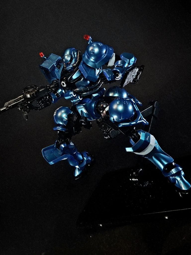 第1話に登場。軍警察の特殊部隊向けにカスタマイズした軍警ザクのバリエーション機。形式番号はMS-06-SSPEX。全体のカラーリングは黒に変更されている。通常仕様と違い誘導灯のような棒状のパトランプが後頭部から伸びている。頭部前面にはアンテナモジュールのような箱状のデバイスが設置されている。指揮官機も存在し、その箱型モジュールからロッドアンテナが突き出ている。背面に長距離移動用のためなのか、大型の角柱状の推進機(噴射ノズル三基)と大腿部に装備されたものに似た形状の球形プロペラント4基が接続されたブースターを装備しており、必要に応じてパージ可能。