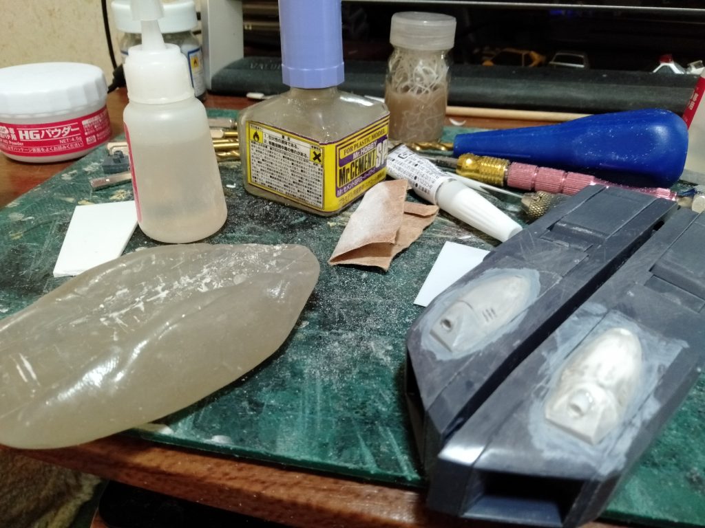 さてと、バランス取りと表面処理の合間に”マウント式バルカンポッド”を増設していきます。エヴァ―グリーンのプラパイプを半分にして、半円にしたもので外観を仮仮定で張り付けて、そこにＳＳＰパテで整形していきます。その後、”型取りくん”を使って複製した物を反対側に付けて、整形し直しました。3mmのプラパイプにてバルカンの砲塔を再現します、そして仕上げとして”サフ”を塗り、ＳＳＰパテの表面を保護して塗装のりも良くします。　　　　・・・おかげでMGガンダムを跨らせて固定は出来なくなりますが（笑）。