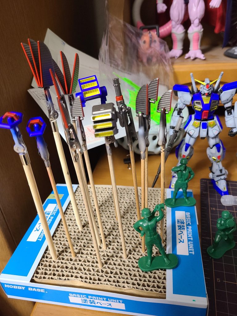 色分けされてない部品たち。4時間くらいマスキングテープと格闘しました。青いバーニアの金と、肩のフィンの赤×2が強敵でした。その他、エナメル等で黒い部分は筆塗り。スミイレもエナメルで