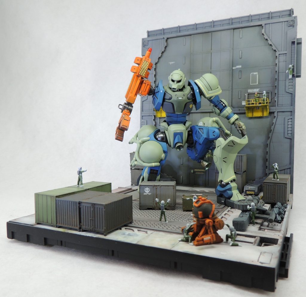 補給艦パプア内部での作業シーンをイメージした簡易ジオラマ。市販のジオラマベースキットと鉄道模型用コンテナを組み合わせました。フィギュアはビルダーズパーツを使用。