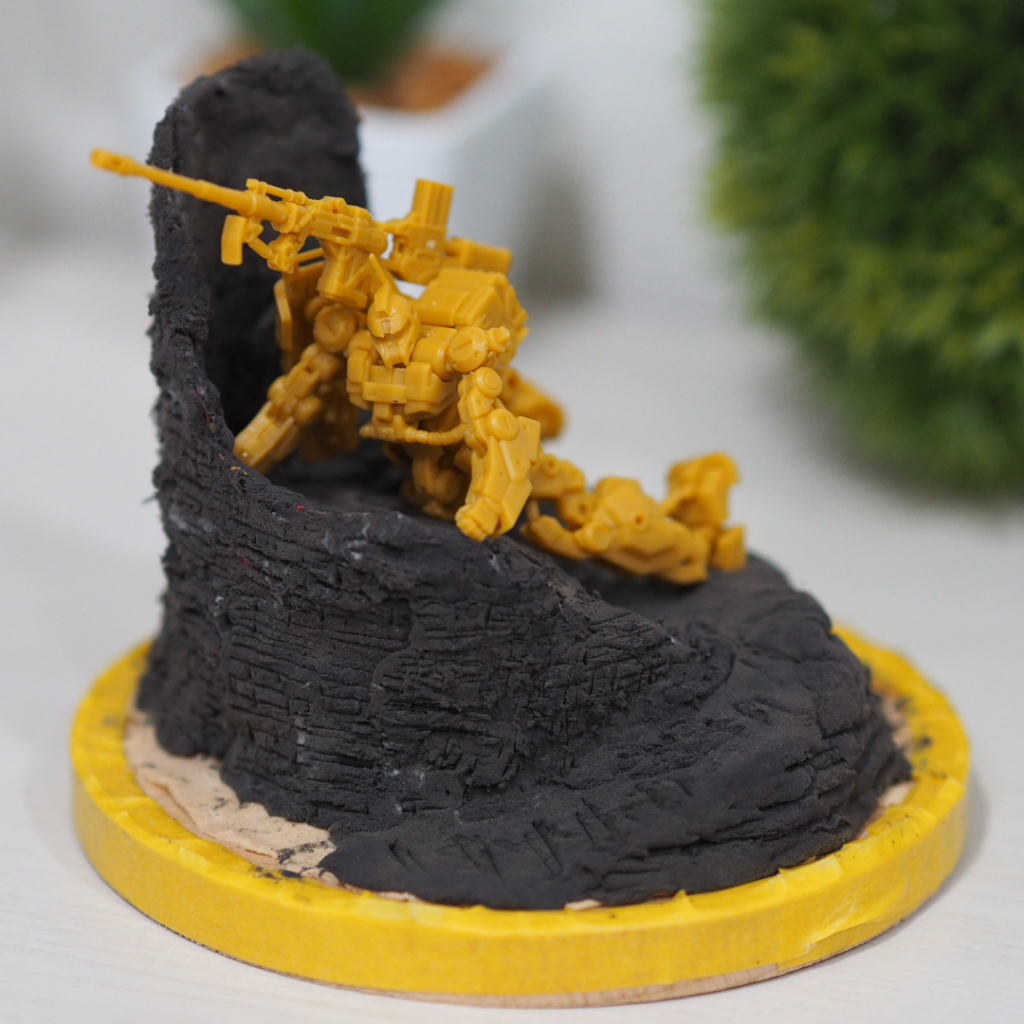 作成中はこんな感じ。ほとんど百均で揃えてます。木製コースターに木粉粘土と軽量粘土。ナイフでレンガ模様を彫ります。ザク1本体の稼働部を調整。左は開き手にしたかったけど、強度が心配だったので辞めておきました。