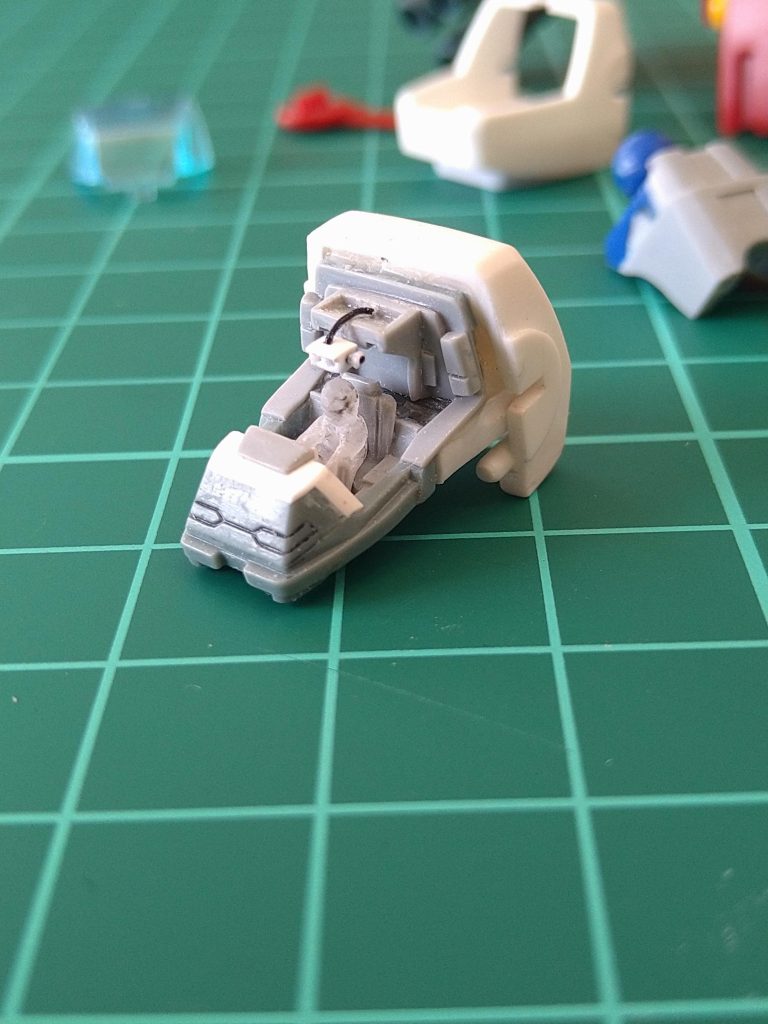 今回のフィギュアはハヤトさん…前回投稿させて頂いた〘コア・ファイター〙での〘アムロ〙よりももう少し小さく…😂タイヘン💧そしてヘルメットのガラス部分ももう少し奥行きがある様に見せたいと思い 1/144のフィギュアをレジンで複製後…切って削ってくっつけて😕…大きさやポーズの制作…ですので、もちろん頭部ヘルメット部分もクリアのレジン製…体の部分塗装後ヘルメットのガラス部分にクリアグリーンの塗料を〘チョン〙😚…結果…そこまで極端に変わったわけではございませんがアムロのヘルメットのガラス部分よりももっと、奥行が取れガラスっぽく見える様になった様な気がするようなしないような…😶だがしかし!…ここで大問題発生!😱…その写真…写して…ない…😭😭😭ナンテコッタイ💦🥺ウ…ウソじゃないよ…🙄どうせキャノピーではっきり見えなくなるるし〜😋小さ過ぎてよくわからないしぃ〜😏まっいっか!🙄…と言う事で次行きます!😑…すみません😭😭😭😭😭😭オ~~💦その後コックピット制作…ガンタンクの照準器はガンダムや、ガンキャノンのようにシート〘横〙ではなく、シート〘上〙に付いているようでしたので、その様に制作…😨…1㍉プラバンを1㍉×1.5㍉にカットしてスコープ部分、0.5㍉の穴2つ開け、アームの取り付け部と横にあるダイヤルを取り付ける為に0.3㍉のキリで穴あけ…😅そのアームの材料はそろそろ買い替え時の〘百均庭ぼうき〙の毛の部分…内緒で一本ハサミで〘✂️チョキン!〙🤫シーそれを使って取り付けました🤣ナイショッ!とにかく小さ過ぎて〘どうせそこまで見えないのに…私は一体何をしてるんだ…😑〙と思う瞬間もありましたが😅なぜか夢中になり楽しく工作しておりました😁こんな感じでコックピット工作完了でございますす!😋.