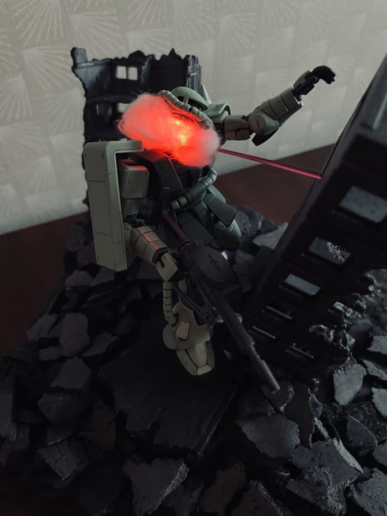 頭を撃ち抜かれるザクの別アングルからのショットです。