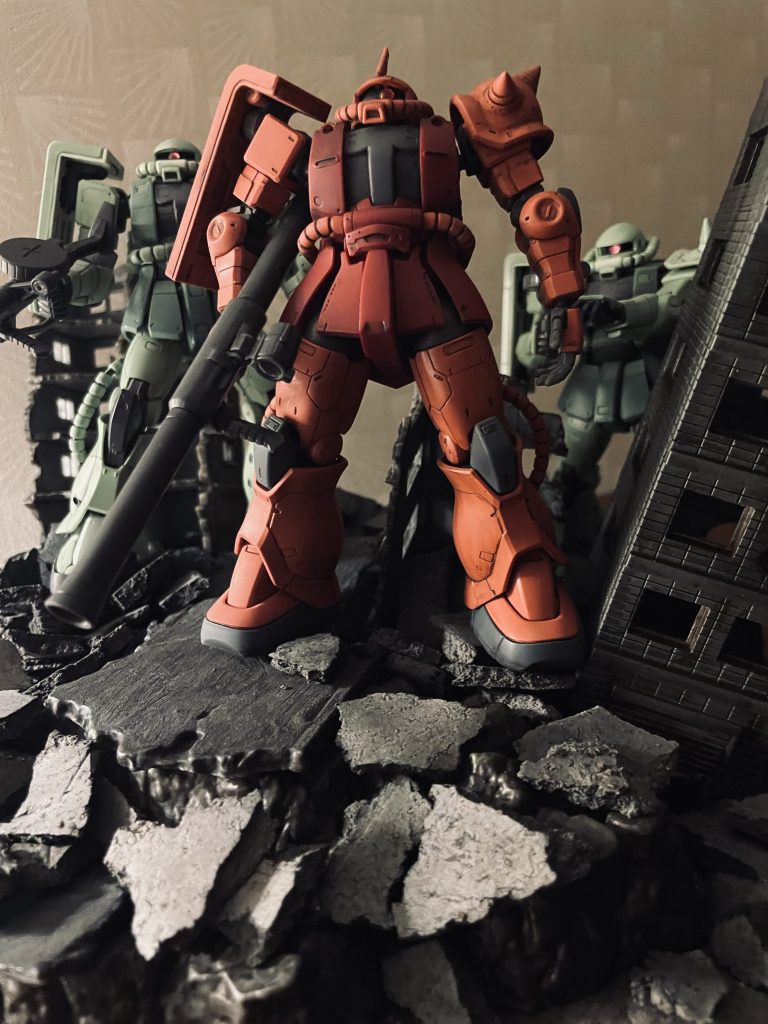 「ガルマ、散る」といえばこのカット、ガウから地上に降下する3機のザクかと思います。シャア専用ザクはオリジン版です。バズーカのみアニメ版のバズーカに換装しています。オリジン版に付属するバズーカは大きすぎて地上での戦闘には適さないかと。オリジン版ザクはRGザクと比較して脚部構造がしっかりとしていて非常に安定感があります。