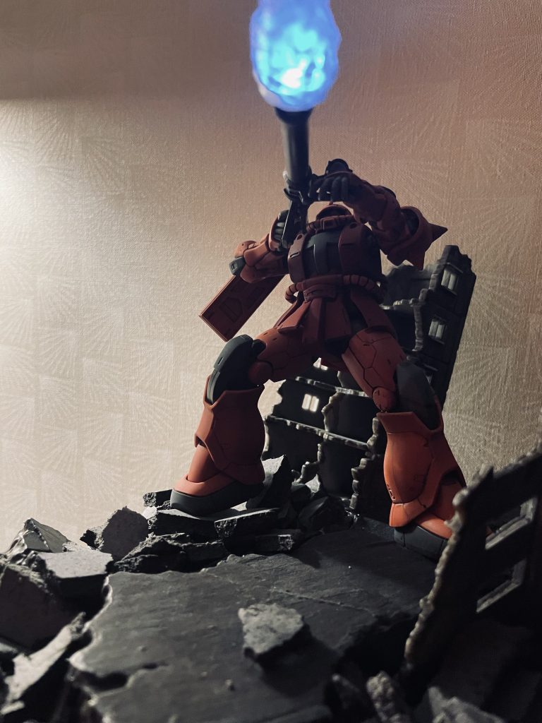 バズーカを放つシャア専用ザクを別アングルから。狙う先はガンダム。トリプルドムセットのバズーカ発射エフェクトパーツを砲身へ挿入し水色の磁石式LEDを仕込んで光るようにしています。