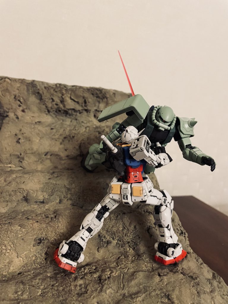 ビームサーベルの柄(つか)をザクのコクピットへ押し当ててビーム部分は背中に逃しています。支持棒等は使用しておらず、ベースへの固定もしていません。ザクのコクピットへ押し当てた柄を支点としてその重量に耐える構図です。version 2.0の脚力が活きました。