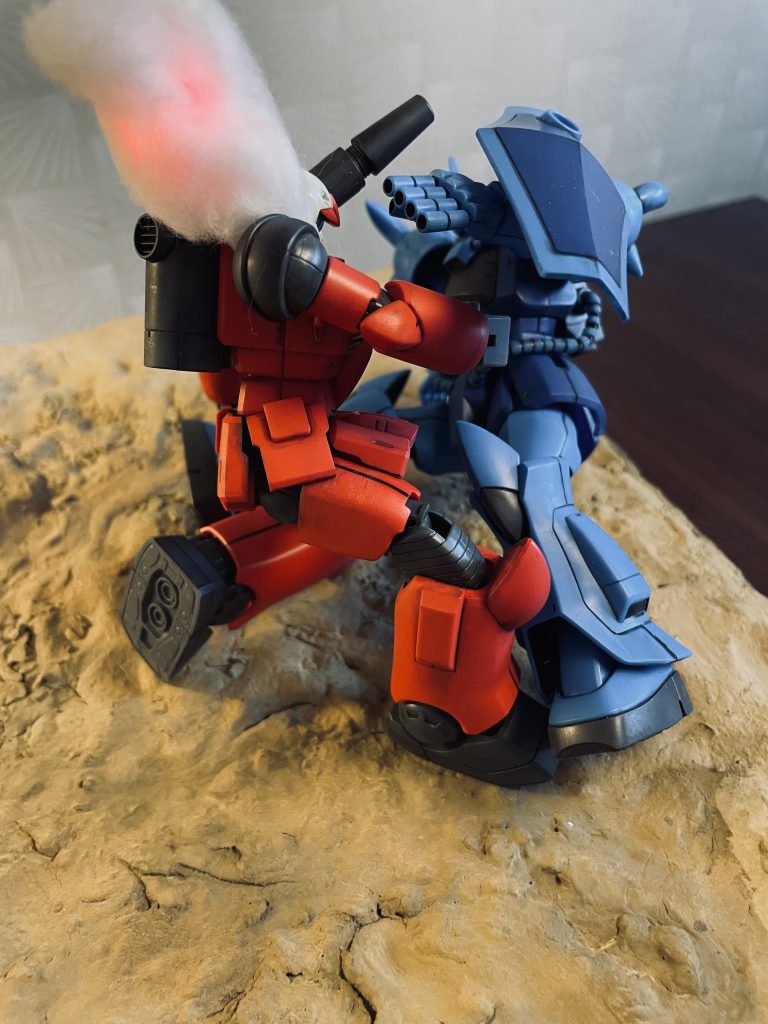 右腕を地面に打ちつけた体勢から反転し、左のマシンガンでキャノン砲を吹き飛ばすまでの一連の動きが素晴らしかったと記憶しています。両腕に武器が仕込まれているモビルスーツならではの戦闘演出でした。