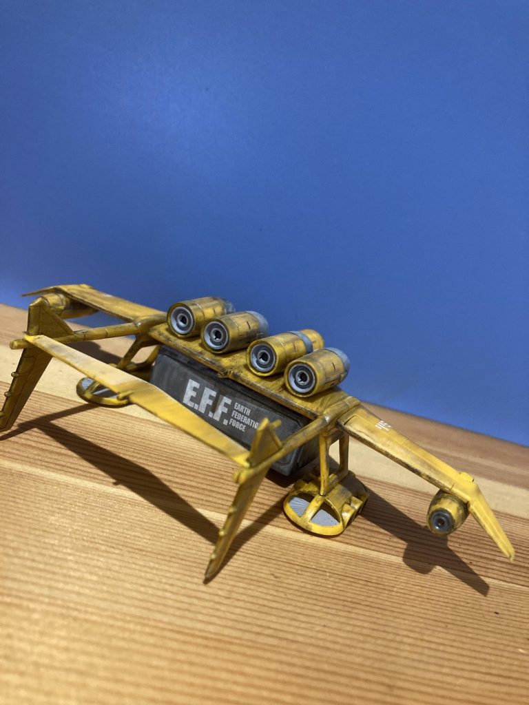 背面。後方の水平翼は設定・正規の位置は地面スレスレの両垂直翼下端ですが・・・それだと陸上においてコンテナを迅速に交換したい時やMSを空挺降下させる際に普通に接触したり邪魔になる気がして水平翼を上方へ位置変更