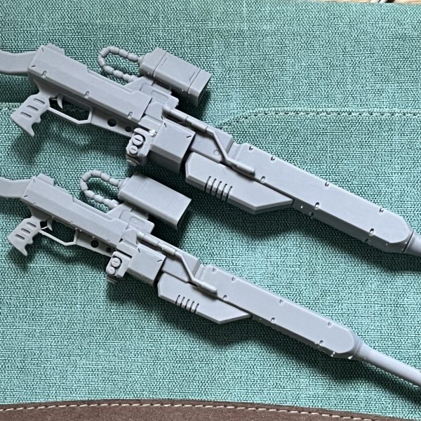 ゲルググとのサイズ比が出ているジョニー・ライデンの帰還3巻口絵を下敷きにFusion360で設計。設定上、ライフルの大きさはゲルググより少し小さい19m弱といったところでしょうが、劇中では明らかに大きく描かれているのでバランスはそのまま23cm程度のサイズとしました。…が、MGゲルググver2.0はかなり大柄なキットのため、持たせてみると小ぢんまりした印象になってしまいます。そこから、ちょうどいい大きさに思えたスコープ以外を15%拡大し、最後部の箱型ユニットをさらに大きくすることで納得のサイズになりました。（2枚目）