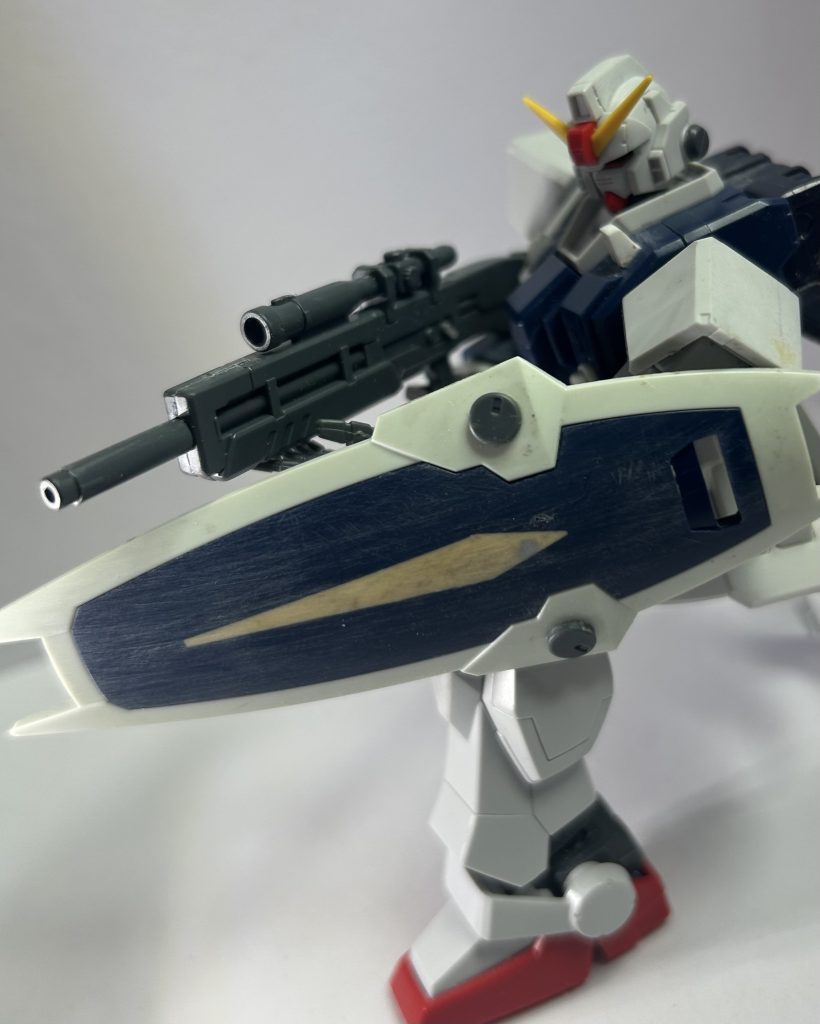 武器。ビームライフルはいつだかのキャンペーンのヤツ……のベースで売ってる方。スコープが付いてて命中精度が高そう。このライフルかなり好みだから大量に欲しい……。側面に、ア・タ・レの切り替えレバーをイメージしたディテールをつけました(ア-安全装置、タ-単発、レ-連射……なお、現実世界の次期小銃には3-三点射が無くなった為、3は存在しませぬ)。……確実に気に留められないな、小さ過ぎて。シールドはダガーL。陸戦のシールドは小さい……機体本体は軽量化による弊害でダメージ耐久度は低い、と言う設定にしたいからそれに説得力を持たせる為に通常サイズのを付けたい。↓対弾性の高そうな曲面シールドが良いな、けど、連邦のは使いたくないな。↓良い所にダガーLのものが!ということで決定。みたいなノリで決めました。まんま使うと分かりやすすぎなので、パーツ隠しも兼ねて中央の突起をパテでフラットにしました。