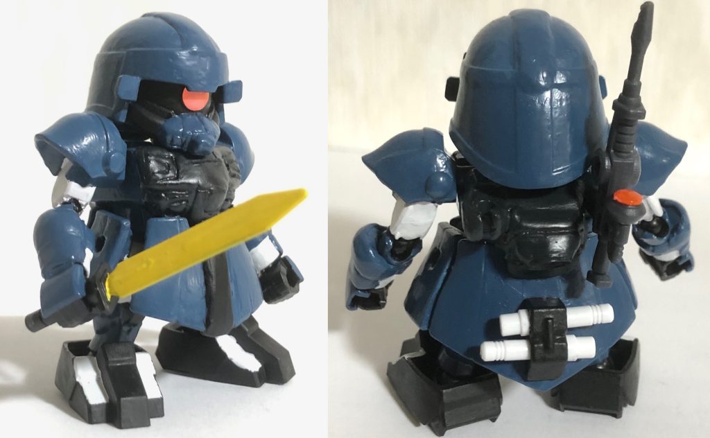 そこで白兵戦用にグフのヒートサーベルをベースにした「ヒートマチェット(画像左参照。オリジナル武器)」をサブウェポンにするプランも進められ、アクトザク・ブレイブの専用武器となった。なお、ビームライフルとビームサーベル、シールドは背中に装備できる。