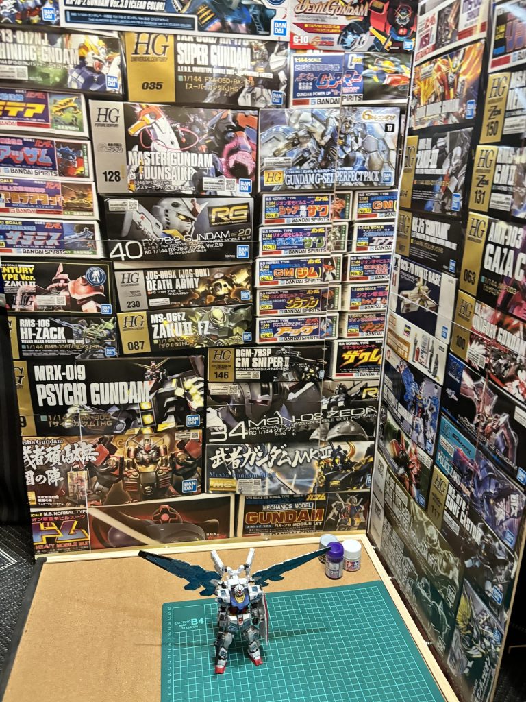 背景には積みプラの壁。初心者の僕が作った作品でいかに見に来てくださった方を楽しませられるかを考えた時に、旧キット祭りでこちらに投稿した際の積みプラの壁が好評だった事を思い出して作りました。実際に壁のサイズに合わせて並べて写真を撮っています。できるだけガンプラ好きが楽しめそうなラインナップにしました！