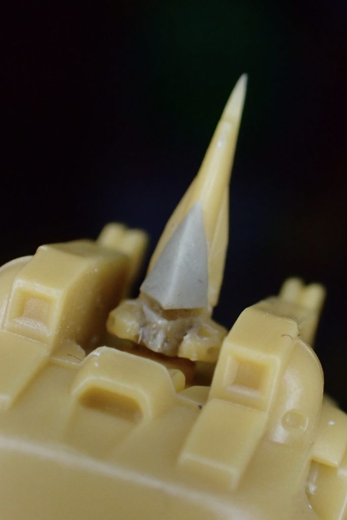 頭部だけ大きく改造しています。額当てとマスクをパテ造形し、モノアイは0.6ミリの穴を空けて、伸ばしランナーの要領で細くした透明プラ素材を埋め込んでいます。