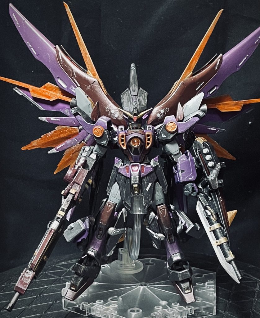 ウイングガンダムの改修ポイント◉ウイングガンダムの名に負けない『ウイング』デスティニーガンダムのバックパックと、ジェミナスの高機動ユニット、ウイングガンダムのバインダーをミキシングして羽を作成。デスティニーの光の翼がなかったので、クリアパーツを切って貼ってエフェクト追加◉3発しか打てないバスターライフルの改修と武装バスターライフルはジャンクパーツとバレルの延長、エネルギーカートリッジの予備を携行する設定に。シールドには実体剣付きのライフルに、ビームアックスを装備し、バスターライフルのエネルギーカートリッジも携行◉カラーリングを『闇堕ち』をイメージウイングガンダムは主人公に大事にされていない印象を受けており、闇堕ちしてしまったイメージのカラーリングに変更しました。