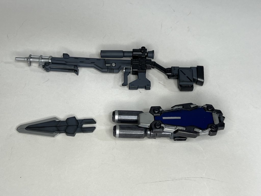 武装はスナイパーライフル、シールドツインライフル、ダガーの3つ。 スナイパーライフルはビルダーズパーツのシステムウェポンを組み合わせて使用しています。 シールドツインライフルはシールド部は昔のおまけでついてくるカスタマイズパーツのものを使っています。(一番くじの低賞にもなったやつですね)ツインライフル部はダブルゼータやふるあまーガンダムの様なぶっとい銃身をイメージしたかったので、紅ウェポンのバズーカ砲身を切り詰めて使用しています。一応3mm軸で接続しているのでシールド部とライフル部も簡単に分離することができます。 ダガーに関してはコマンドクアンタの武装をそのまま使っていますが、腰やバックパックにマウントできるようにマグネットを仕込んでいます。 やはりガチャガチャ武装や形態が変形するのは男の子のロマンだと思います。 あれはいいものだ! (zaku-kao5)