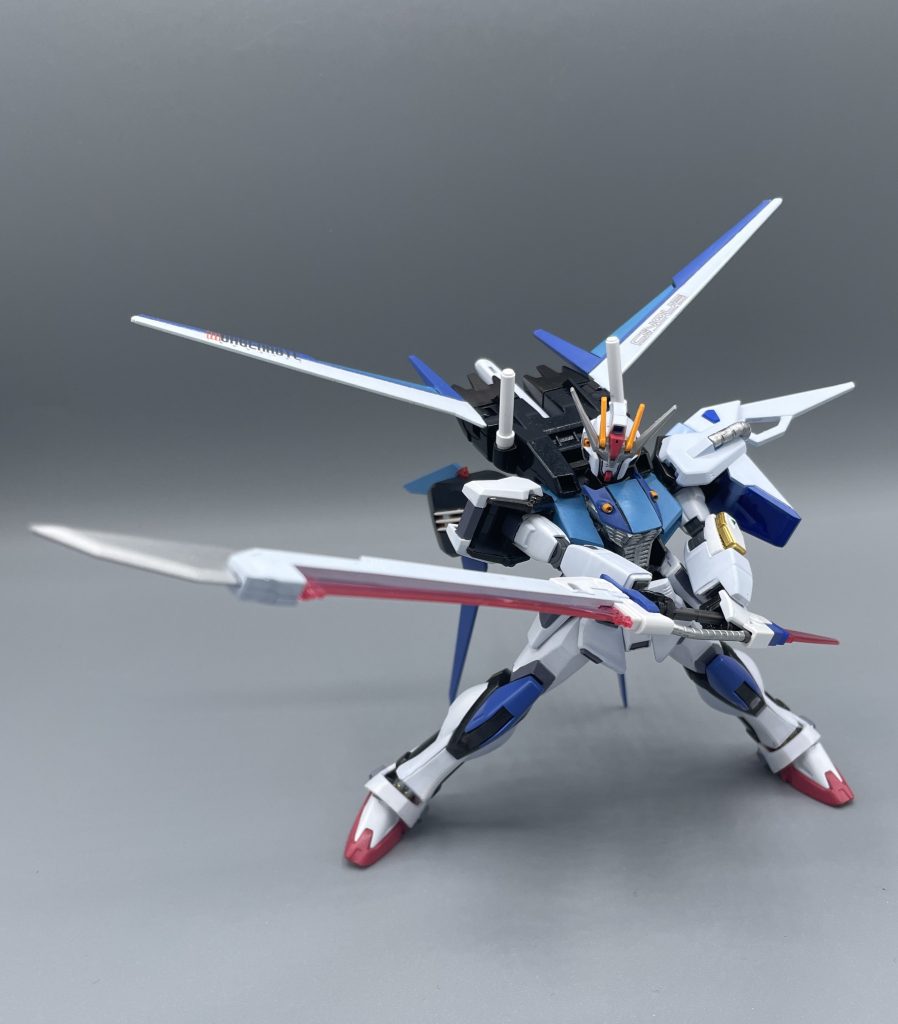 シュべルト・ゲベール　でっかい対艦刀！！ F105はビーム刃が緑ですが、対艦刀のビーム刃がピンクなのは、出力をやや落としているため。強力な武装であるため、エネルギー出力を少々落としても余りあるという設定です。　対艦刀の切っ先は、実体剣らしくシルバー塗装。ガーベラストレートやフツノミタマの技術が取り入れられています。これにより、斬るだけでなく、刺突攻撃も可能となっています。