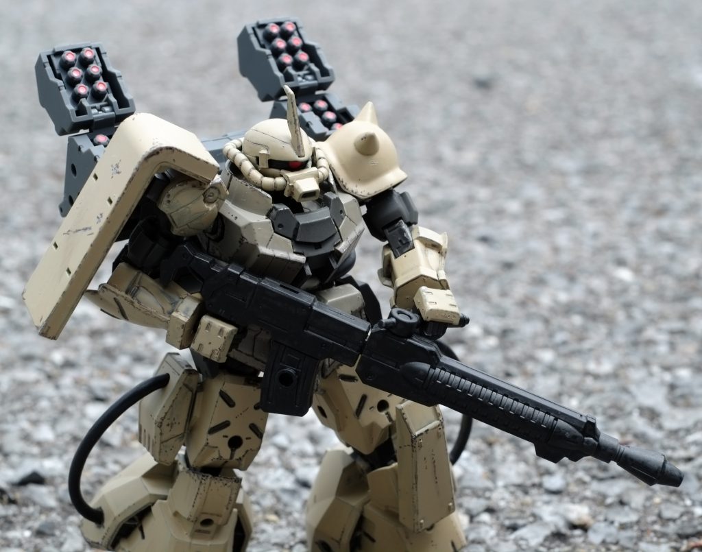 脚がホバーっぽいのでそのまんまで高機動っぽく見えて良いんですよね。一応設定として高機動型で武装を強化した強襲用ということにしてそれっぽい感じにしています。背中のミサイルを陽動にばらまきながらホバーの機動で急接近して手持ち武装で一撃を加えた後離脱する運用を想定。デザートカラーにしたことで、なんか0096年のトリントン基地襲撃戦に居たような気がしてきました。