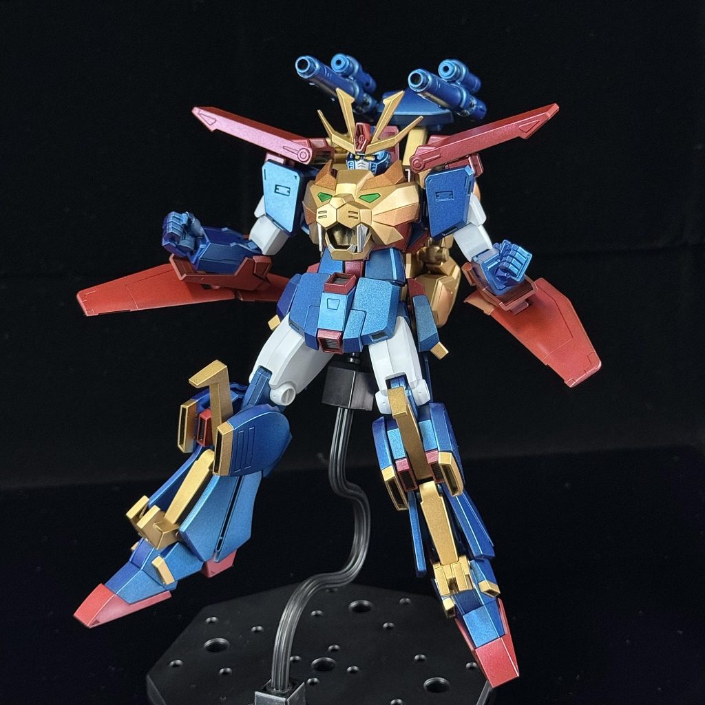 最初にトライオン3を見たとき、「ビルドファイターズ」シリーズの機体って本当にぶっ飛んでるなと思った。ダブルゼータをこんなふうに魔改造して、まるでスーパーロボットみたいに仕上げるなんて、どんな発想力なんだ?しかも、ライオン、ワシ、エイが合体してるって…まさに王道勇者ロボそのものだよね。HG版を手に入れたのは、元の機体をさらにぶっ飛んだデザインにした超合金版が発売された後だった。そのときには逆にHG版の方がシンプルに見えてきて、「じゃあ全身メタリック塗装で仕上げてみよう」って思ったんだ。水転写デカールも要らない。勇ましいスーパーロボットには、そんな飾りなんて不要さ(zaku-kao4)