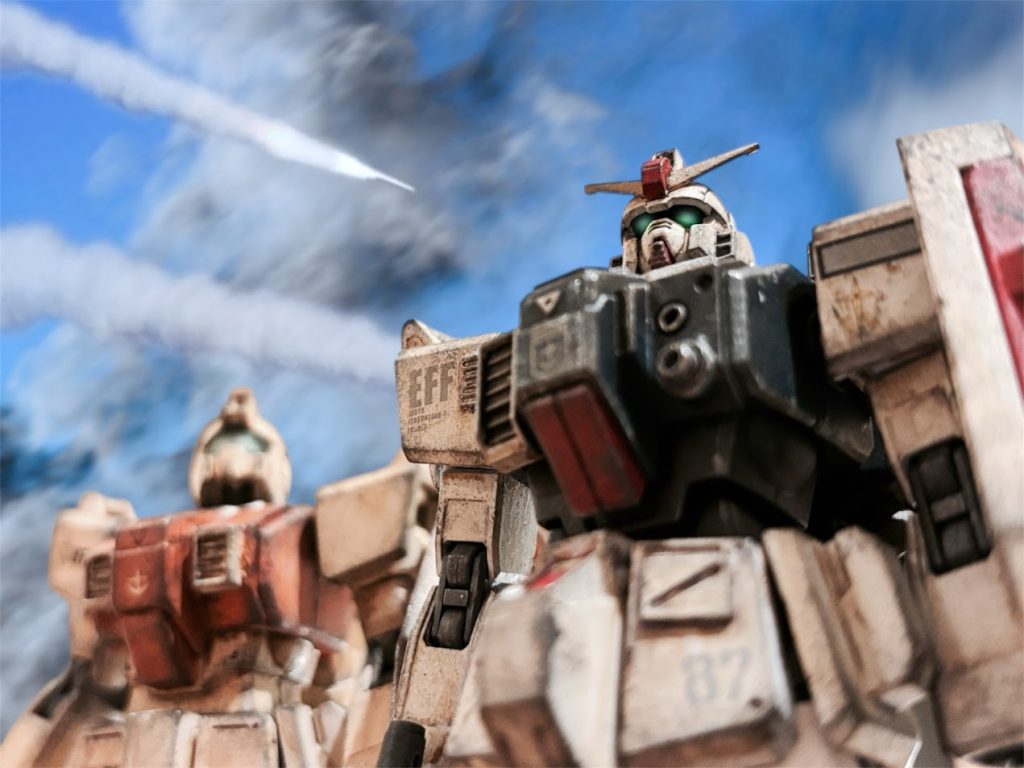 　ふと、甲高い音が頭上で鳴り響き、遥か後方で爆音があがった。味方が展開していない方向からの砲撃だった。ジオンの残存兵力が、まだ抵抗しているらしい。