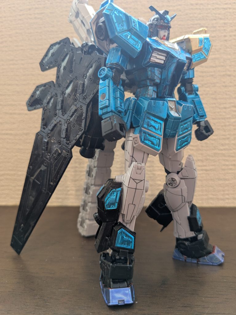 武器を外して素立ちで1枚。頭は髪をイメージしてメタリックブラックで、アンテナ中央は烏帽子をイメージしてコスモメタブルー。隈取りをシルバーで、目をロイヤルメタレッド。体とスカートは、龍のワンピースをイメージして、コスモメタブルーで、首回り、胸ダクト、腰中央は縫い紐などをイメージしてシルバー。左肩は肩当てイメージでイエローゴールド。足はソックスイメージでグラスフェザー周りをメタリックブラック、スリッパ部分を靴イメージでメタリックバイオレット。羽の裏側とバーニアは、マントイメージでメタリックブラックです。グラスフェザーはシールそのままです。これが左肩だったりオーラのイメージだったりで、龍のイメージにバッチリはまった感じがしております。