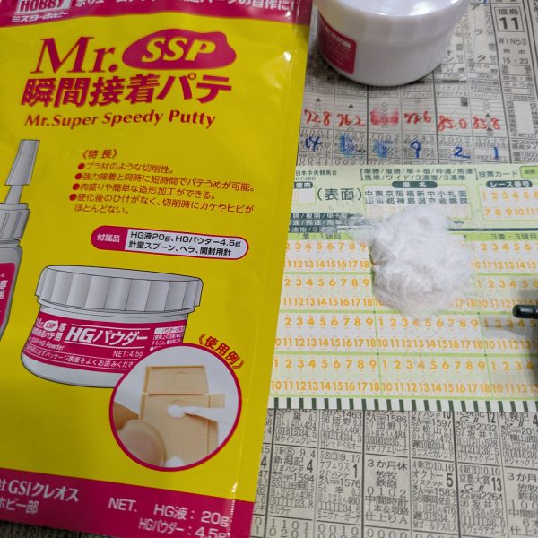 この人、ザクIII改つくってるのかな？と思った皆様、安心してください。作ってますよー。切って貼って、盛って、削っての作業の繰り返しなので大変な割には絵的には地味な作業です。でもいつも無改造な私にとっては久しぶりに懐かしい作業です。エポパテで成形すると重くなってしまうので、軽量化と削りやすいので、アルテコSSPを使っているのですが（誤って名前を覚えているかも？）、我が家で保存していたものはHG液が固まってしまって使用不可能になっていました。粉は大量に余ってるのに⋯。製品を補充しようとして色々探していたのですが、なかなか見つかりません。パッケージ変わってました。見つからないわけだ。私の中では博士みたいな箱絵のやつだったけど、黒い箱と発売元が変わった？のかクレオスからいつの間にか出ていたのてすね。紙箱からアルミ袋に変更されていました。まだ売っててよかった。早速混ぜ混ぜ。混ぜるときのシートは毎週私から搾取を続ける某競馬団体のマークシート。コレが使いやすい。成人の方はぜひ（ダメ？）。久しぶりの刺激臭。たまらん（ヤバい？）。「この刺激臭こそアルテコ（商品名間違って覚えてます）よ！」うーん、久しぶりにモデラーしてる気がするなー。今回、何言いってんだコイツ？という非常に読みにくい＆理解不能な文章かと思いますが、最後に一言「塗装時のマスクと同じくらい、ヤスリする時もマスクした方がいいよ」ってことです。私よりも凄腕のモデラーさんたちが何ヶ月もかかってるのに、私は完成することができるのかなー、と考えてしまう。とりあえずせっかくたくさんキットを持っているので一機は改造せずにそのまま作って比較用に作ってみようかな。やりたいイメージが湧きそう。  （4枚目）