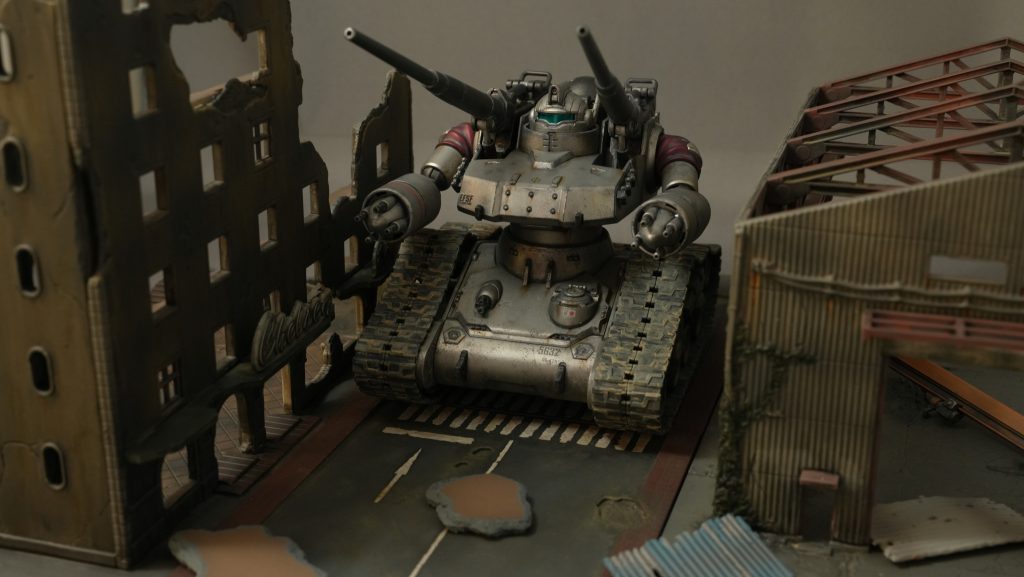 戦禍の市街地を進むガンタンク初期型・・・ジオラマが順調に増えてる(笑)道路はトミーテック ジオコレ コンバットシリーズの「道路A」。左の廃ビルは同「破壊されたビルC」。