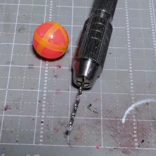 制作中のビットのような物試作モデルが完成しました。マチュの制作時に妄想してたものの制作方法が思いつかずに断念してましたが何となく思いついたので制作開始です。あと3個作るつもりですが…面倒ですが作ると思います。どっかのアニメのように6個装備も良いですが4個目標にします。田舎者なので明日出掛けるのであったら買っちゃうかもなぁ。赤いガンダム…もう無いだろうなぁ。前回ハンマー制作に使用した家にあった浮き球。これにガイドとなるマスキングテープ貼ってマーキングしてピンバイスで貫通しない程度に穴開け。後は買ってきた釣具の赤ビーズ、プラパイプ、真鍮線とバーニアの組み合わせです。塗装するので関係ないですが釣具なのでブラックライトで発光します。固定用のパーツ着けときゃ良かった。何か考えます。🤔ミッションインポッシブル…。  （4枚目）
