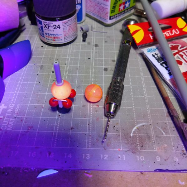 制作中のビットのような物試作モデルが完成しました。マチュの制作時に妄想してたものの制作方法が思いつかずに断念してましたが何となく思いついたので制作開始です。あと3個作るつもりですが…面倒ですが作ると思います。どっかのアニメのように6個装備も良いですが4個目標にします。田舎者なので明日出掛けるのであったら買っちゃうかもなぁ。赤いガンダム…もう無いだろうなぁ。前回ハンマー制作に使用した家にあった浮き球。これにガイドとなるマスキングテープ貼ってマーキングしてピンバイスで貫通しない程度に穴開け。後は買ってきた釣具の赤ビーズ、プラパイプ、真鍮線とバーニアの組み合わせです。塗装するので関係ないですが釣具なのでブラックライトで発光します。固定用のパーツ着けときゃ良かった。何か考えます。🤔ミッションインポッシブル…。  （5枚目）