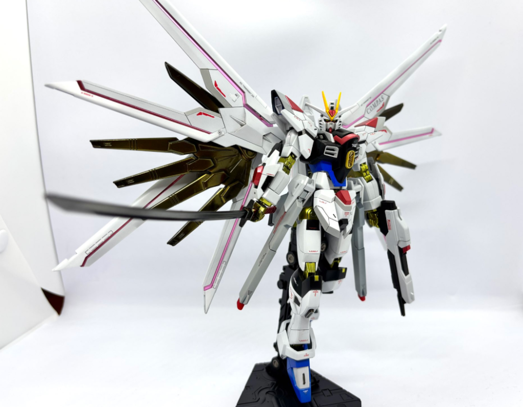関節部分とプラウドディフェンダーの金羽部分はボーンペイントのボーンミラーⅡ + クリアイエロー(+一部レッド)の調色でメッキ風塗装やってみました。(肉眼ですともっとテカテカしてるんですが iPhone カメラだとこれが限界でした。) 塗るのが下手すぎて試行錯誤しまくった結果追加で塗料買う羽目になり、ボーンペイント系の塗料だけでマイフリのキットと同じぐらいの料金かかりました。今回の経験は次の次ぐらいに作るであろうドラゴンガンダムの塗装の時に活かそうと思います。