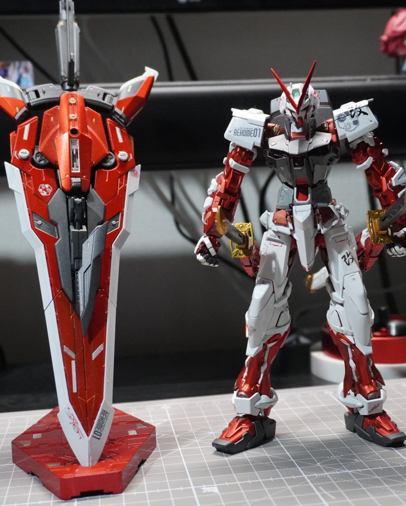 タクティカルアームズ（背面装備）は飾る際に収納できないので大剣の状態にしてました。結果、装備させるときの変形方法を忘れてしまい、このアストレイは２度とタクティカルアームズを装備できない可能性が…塗装は赤をメタリック塗装で艶アリ・なしのトップコート分け、白い装甲は光沢塗装で仕上げました。