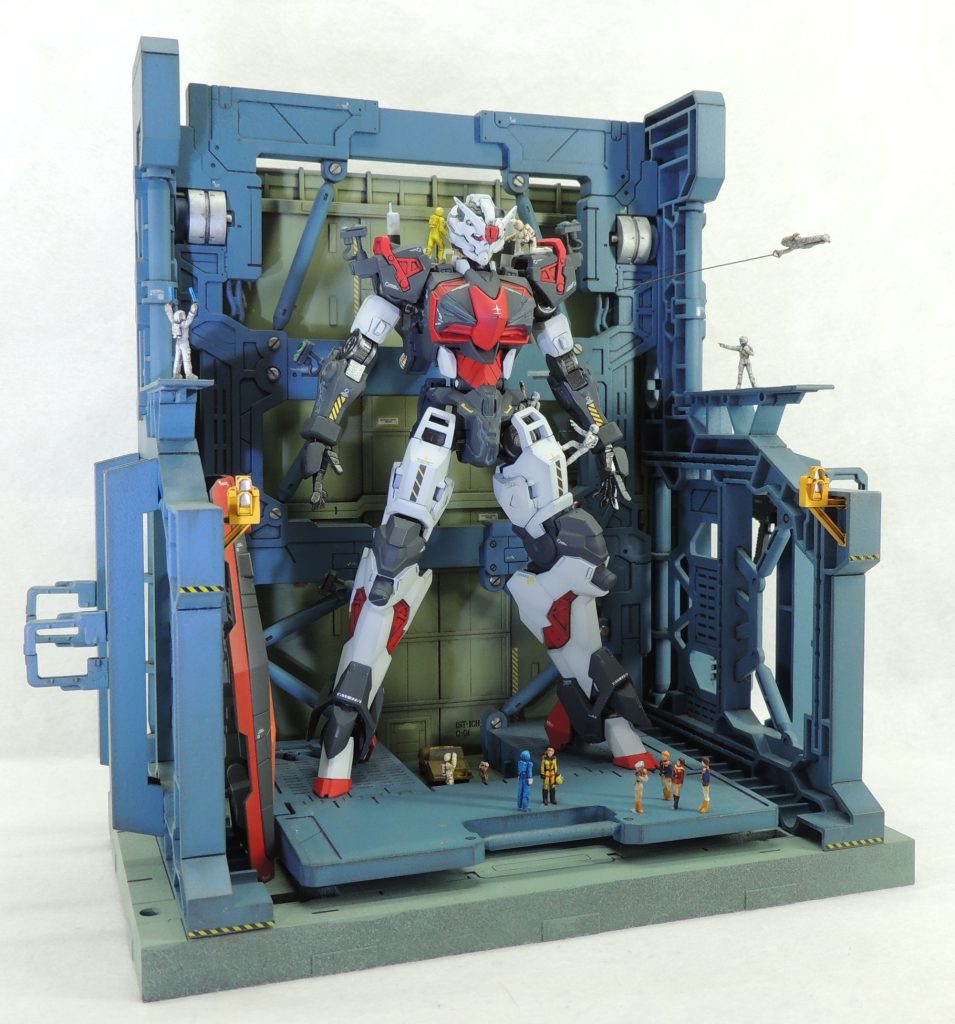 過去作の格納庫の簡易ジオラマにディスプレイした様子です。フィギュアはビルダーズパーツのほか、ランナーやパテから自作したものを使用しました。