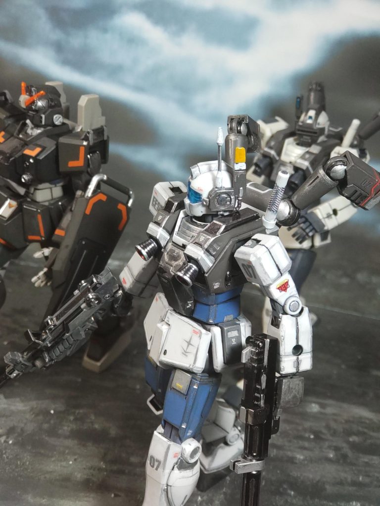 「それでは任務の説明をします」モーリン伍長がいつもの説明をしてくれる。「今回の任務はジム・ナイトシーカーⅡの実戦テストです。ジム・ナイトシーカーとの性能を比較しますので、僚機と連携を取りながら、工場内に潜む敵MSを撃破してください」「なぁなぁ、モーリンちゃんよ〜。何なの、その工場内のMSって❓️」ジム・ナイトシーカーⅡに乗ったフィリップ少尉が当然の疑問を口にする。こんな辺鄙な所、MSはおろか敵がいるとすら思えない。「そいつは俺が説明しよう」アルフ・カムラ技術士官が割り込んできた。「ところでユウ、そいつの感想はどうだ❓️」と、いきなりこっちに話を振ってくる。「………良い機体だ。が、それだけだ…」今、俺が乗っている機体は陸戦型ガンダム。ブルーディスティニーの元となった機体だけあって性能はすこぶる良好。しかし、奪われた2号機に対抗するには、まだ力不足を感じずにはいられなかった。「……やはりか」アルフも悟ったような口調で呟く。「そいつは、連邦軍が博士に内緒でEXAMシステムをコピーして移設したものだ」「オイオイ❗️そいつにも、あのヤバいシステムが積んであんのかよ⁉️」「そうだ。だが、見ての通り何の反応も無い。おそらく博士が用意したハードを使わないと、ろくにシステムは作動しないらしいな。だから、1号機はジム頭だったんだろう」そう言えば、最初はジムで実験してたが性能を満たせず、胴体だけ陸戦型ガンダムに換装した話を聞いた事がある。つまり、EXAMシステムは簡単に量産したり移設できる代物ではない、という事か…。「そして、ジオンも同じような事をやらかしていたらしい」「同じ事って何をですか❓️」ジム・ナイトシーカーに乗るサマナ准尉も話に加わる。「ジオンにも、EXAMシステムを積んだは良いが性能を満たせず廃棄したMSがある、と博士の書記にあった…」「おいおい、それってまさか…」