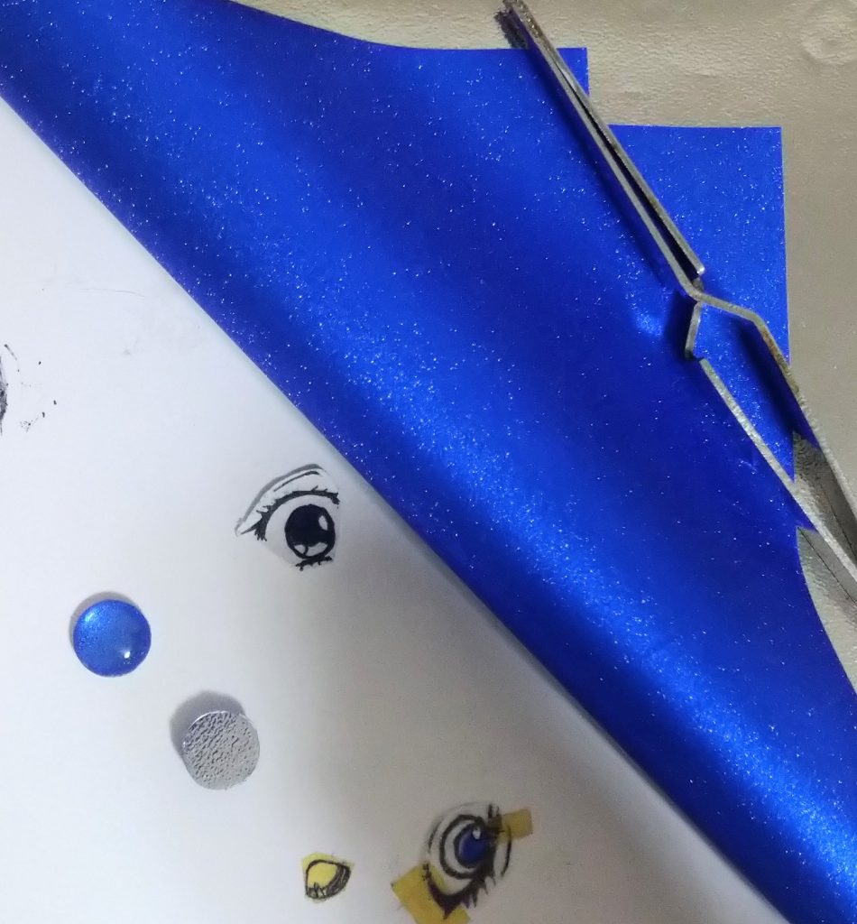 ダイソー素材で構成 お目目はクッションゴム　クリアー＋グリッターちよがみ　青色 セリア髪型抑えに使用 布用接着剤（ シリル化ウレタン樹脂入りのやつ） 台座山田製作所ディスプレイスタンド