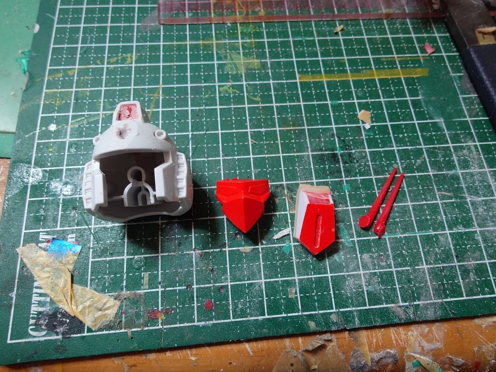 ここからは制作過程です頭はまず元のガンダムの顔を切り離しマスクをパテなどを使いレッドウォーリアのマスクにしました角は赤龍頑駄無のパーツをプラ板で一回り大きくして裏にパテ盛ってヘルメット部分に密着するようにしましたヘルメット部分は角飾りの部分が綺麗につくように少し削りました