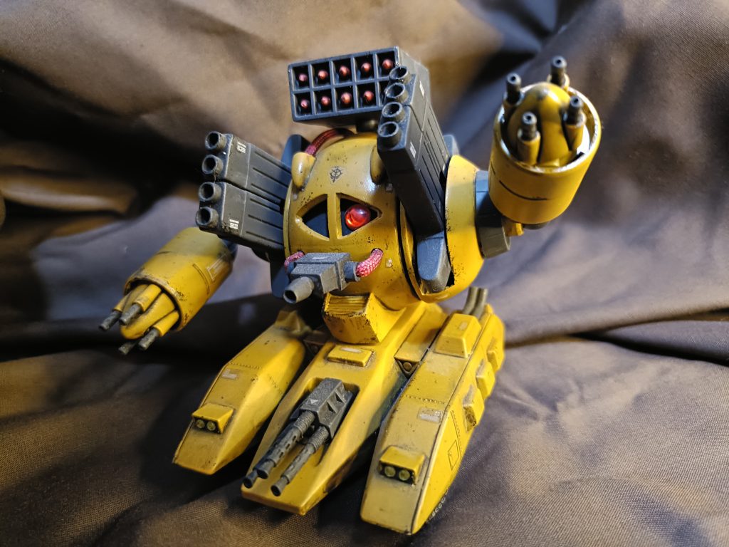 戦闘仕様。戦闘フォーマットのため、モノアイが赤く点灯。頭部にミサイルランチャー。両腕に四連機関砲。両肩にロケット砲。前部に三連機関砲。口部のレーザートーチも出力が上がりビームガンになる。