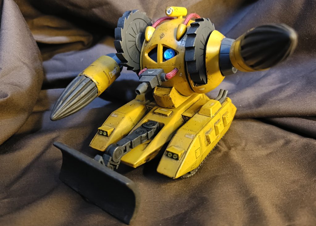 採掘用仕様。作業用フォーマットのため、モノアイが青く点灯。頭部にライト。両腕は採掘ドリル。両肩に伸縮カッター。前部に大型ショベル。口部はレーザートーチ。