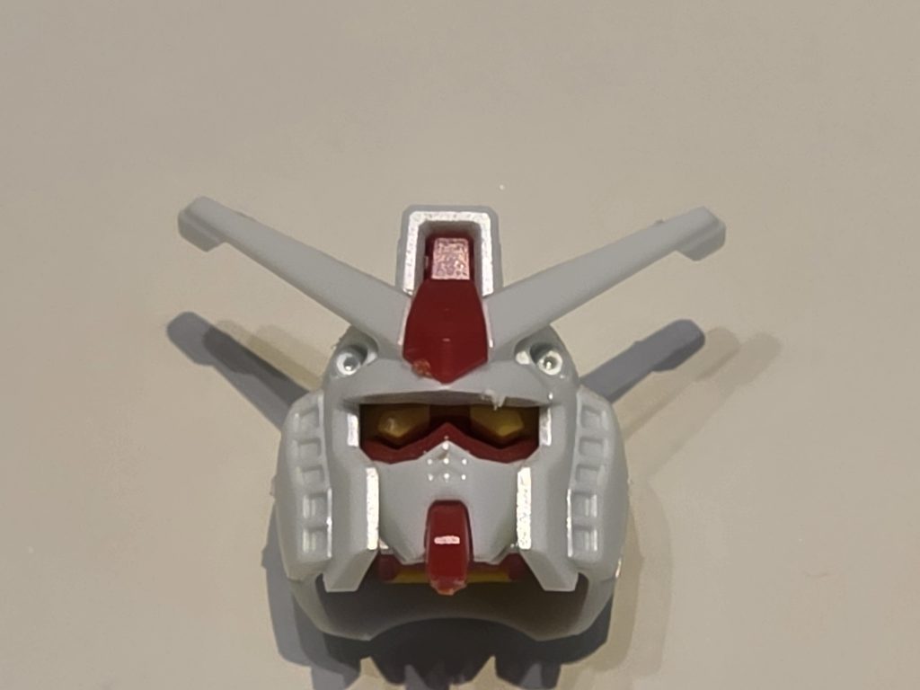 万博ガンダムくんの頭です。本当は一昔前の食玩のガンダムです。万博ガンダムのヤスる前の写真は撮影し忘れました。安全対策でアンテナが丸まっていますね。これ、ダサくないですか？ヤスリましょう。