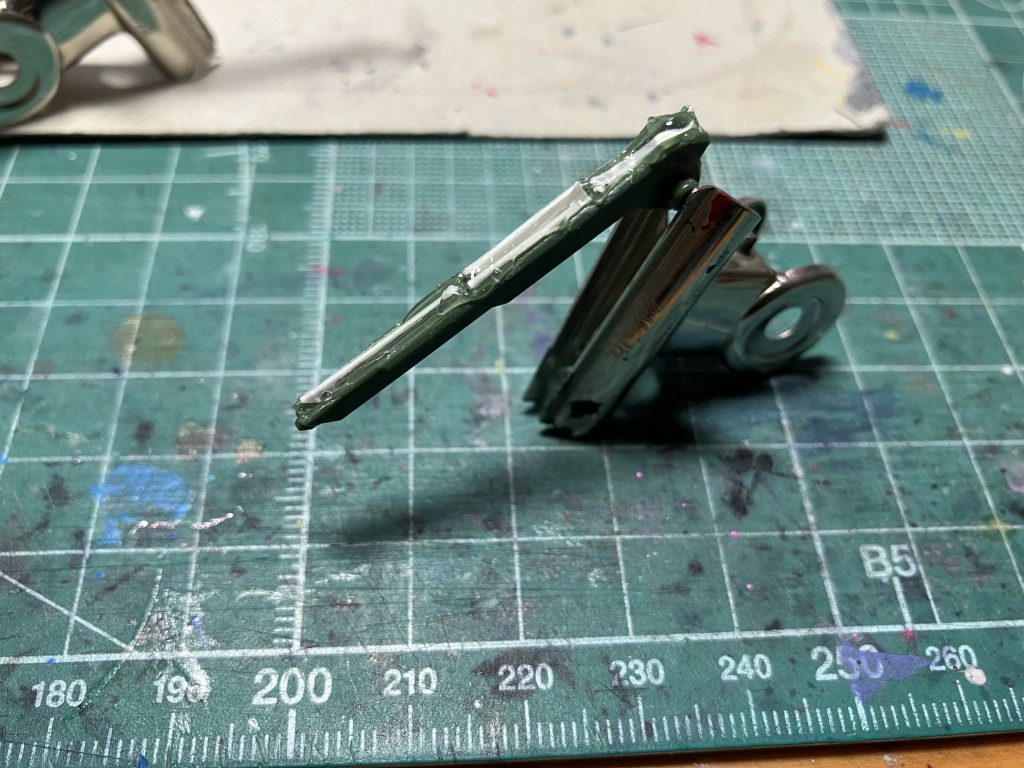 ブラスト特有のパーツではシルエット上部のデリュージー超高初速レール砲の肉抜きが目立ちます。プラ板とゼリー状瞬着で埋めて整形しました。エポパテをこねるのがめんどくてよくやる手口ですが、うまく埋まらないことも多いので今後は諦めてパテ埋めします。 塗装はガンダムマーカー中心です。白=Mr.水性サーフェイサー1000(ホワイト)黒=Mr.水性サーフェイサー1000(ブラック)緑=水性ガンダムカラー ブラストインパルスグリーングレー1=ガンダムマーカー ガンダムグレーグレー2=同メカグレー赤=同レッド青=同ブルー黄=同イエロー デカールはガンダムデカールのRG νガンダム用をメインに、Vertexのデカールを一部に織り交ぜています。最後は水性ホビーカラーのつや消し+UVカットスムースクリアーつや消しを1瓶ずつ混ぜてトップコート。肘膝関節にホイルシールの縁の銀色の部分を切り出して貼りました。