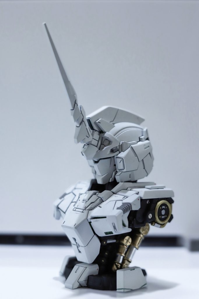 メカニカルバストシリーズはプロモーションが良いですよね。今回の目標はどれだけスタイリッシュに魅せるかでした。私の中でユニコーンというと真っしろ＝情報量が少なめです。なのでデカールはグレー、スミ入れもグレー。とにかく真っ白さは残したつもりです。ですが筋彫りが深すぎて影が黒くなったのは改善点でした。塗装は黒→グレー→白の順に重ねました。トップコートはつや消しです。頭部の電飾はマグネットでオンオフが切り替えられるタイプの物を使いました。胸部はエクシア-トランザムカラーに付属していた緑色のルミナスユニットを使いました。水性塗料での塗装は初めてで厚塗りになってしまったからなのか所々塗装剥げが起きてしまいました。そこさえクリアすればかなり良かったのに惜しかったです。でも良い仕上がりになったので良し⚙️MS Mechanical Bustシリーズはこれからも少しずつ作りますので次回も是非見に来てください😊ありがとうございました！ 機動戦士ガンダムUC RX-0 UNICORN GUNDAM . Mechanical Bust DX