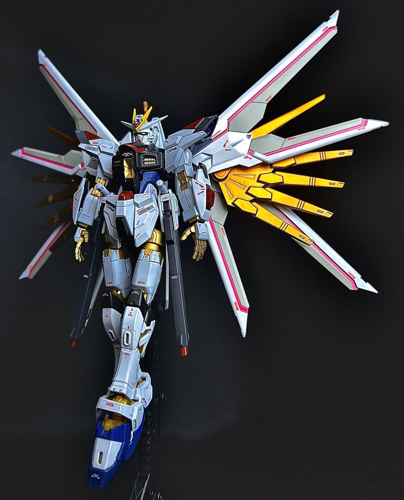 こだわった点はHGマイティストライクフリーダムガンダムの頭部が面長に見えてしまい個人的に好みじゃなかったので、造形が好みなRGから流用。腹部のビーム砲もHGの楕円の造形が好みではなかったのでRGから流用。脚部も太さはありますが短く見えてしまうので、こちらもRGより流用しています。プラウドディフェンダーの金色翼部分の、1番上のパーツが極端に短かったので20mm延長も行いバランス調整ました。プラウドディフェンダーの白い羽部分は、オリジナルでグレーと白で2色展開にしてみました。ストライクフリーダム弐式本体とプラウドディフェンダーは金色塗装色を変更しました。