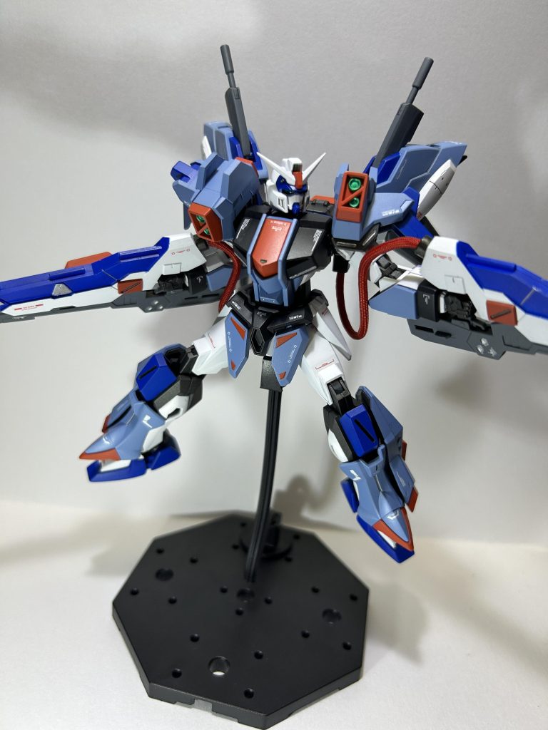 アクション1。カラーリングはデュエルブリッツをベースにしつつ全体的に明るい色合いに変更して、自分の好きなヒロイックな感じを目指しました。ですので、基本色も白にしてアサルトシュラウドの水色も少し明るめに。元々黄色だったパーツはオレンジにしてバスターガンダムらしさを出せればと、、、