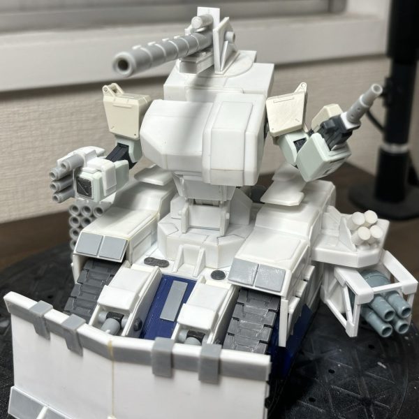俺の武器を知ってるかい？120mm低反動キャノン砲！40mm4連装ボップ・ミサイル・ランチャー！15連装ロケットランチャー！4連装バルカン！100mmマシンガン！きょうもじけんだ、ダイナマイト刑ー事ー！このネタ覚えてる人いるだろうか。…というわけでガンタンクですが、中破した陸戦ジムや量産ガンタンク、拠点の防衛兵器を使って組み上げたワンオフ機体という設定です。そのためマニュピレーターなんて繊細なものは排除して腕部に直接武装を付ける形にしています。リロードはしない想定なので、100mmマシンガンはマガジン大型化しようかな。 （1枚目）