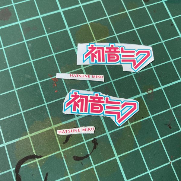 次の制作は～？初音ミクカラーで満足出来ずに痛車デカールで痛くする事に。細かく切って何をするのか……。ついでにFMG初音ミクのデカールも使ってみるか…さて、どれが使われるか…。ってかこれ､自動車模型用デカールじゃんガンプラに使って大丈夫か？！痛さは強さ！明日へ続きます。（2枚目）