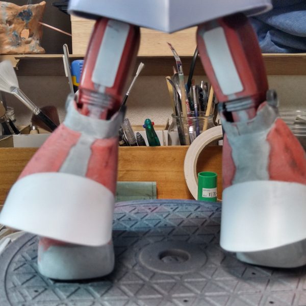MGドムの足を使うのが一般的ですが、昨今そんなもったいないことは出来ないので、ジャンクの旧キット1/100ゲルググの足で作っています。全体的に5ミリ幅増し。膝下スカート5ミリ延長し、後部の膨らみはプラ板で作成。靴をかさ上げ5ミリ、裏側をhgドムのものが余ってたのでそれを設置、ポリキャップ接続に変更、形状はMGパーフェクトジオングを参考にエポパテでそれらしくしました。股関節のパーツはプラ板とポリキャップで新造しました。もう少し膝下が長い方が良かった気がしますが、もう弄る気力がございません(T0T)とりあえずこれで塗装に入ります。 （5枚目）